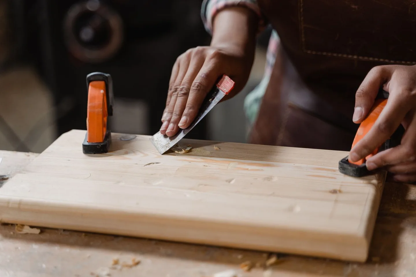 Hands working on a clamped wooden board