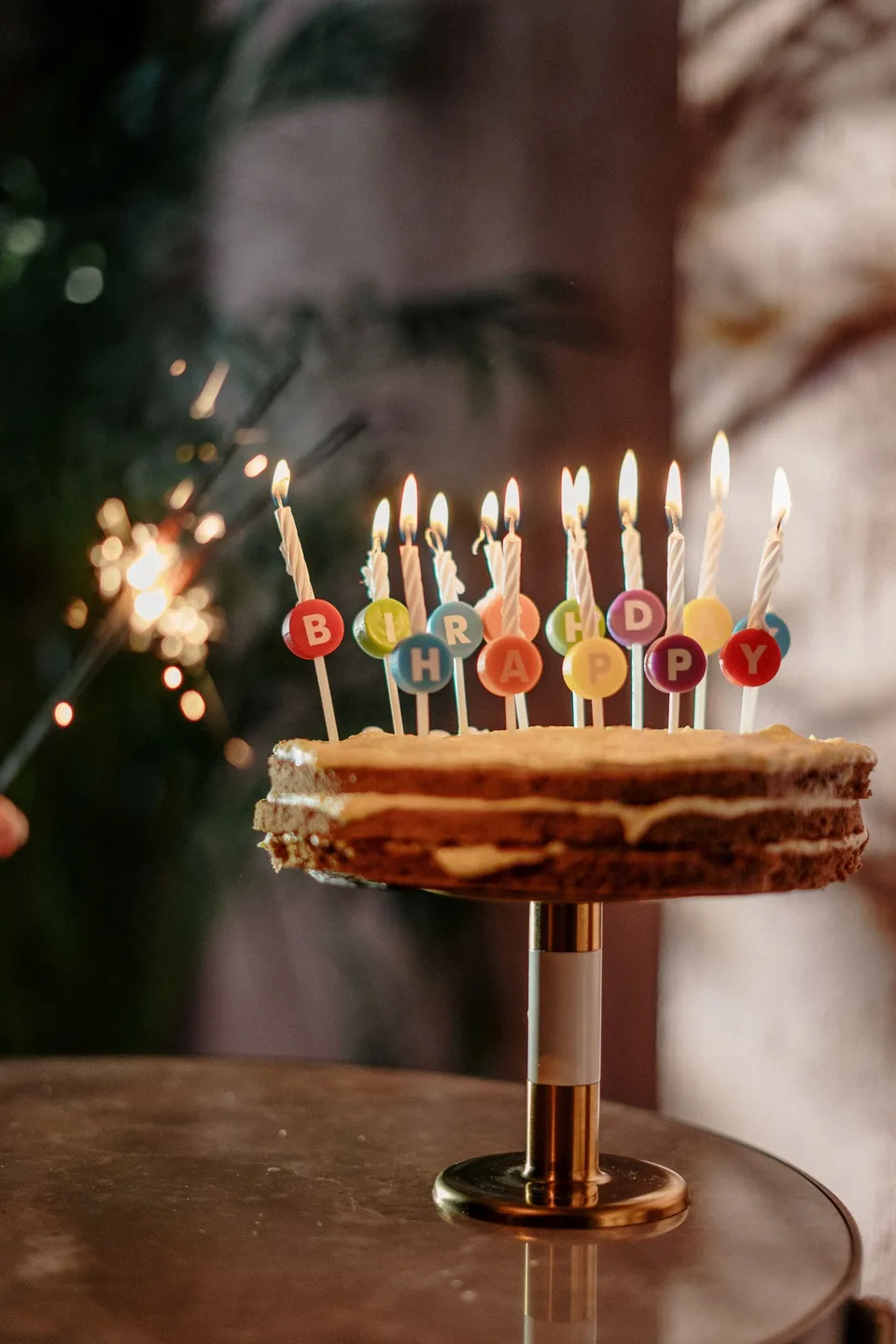 A birthday cake lit with several colorful candles