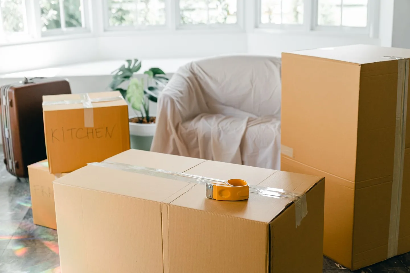 Cardboard moving boxes and covered furniture in an apartment
